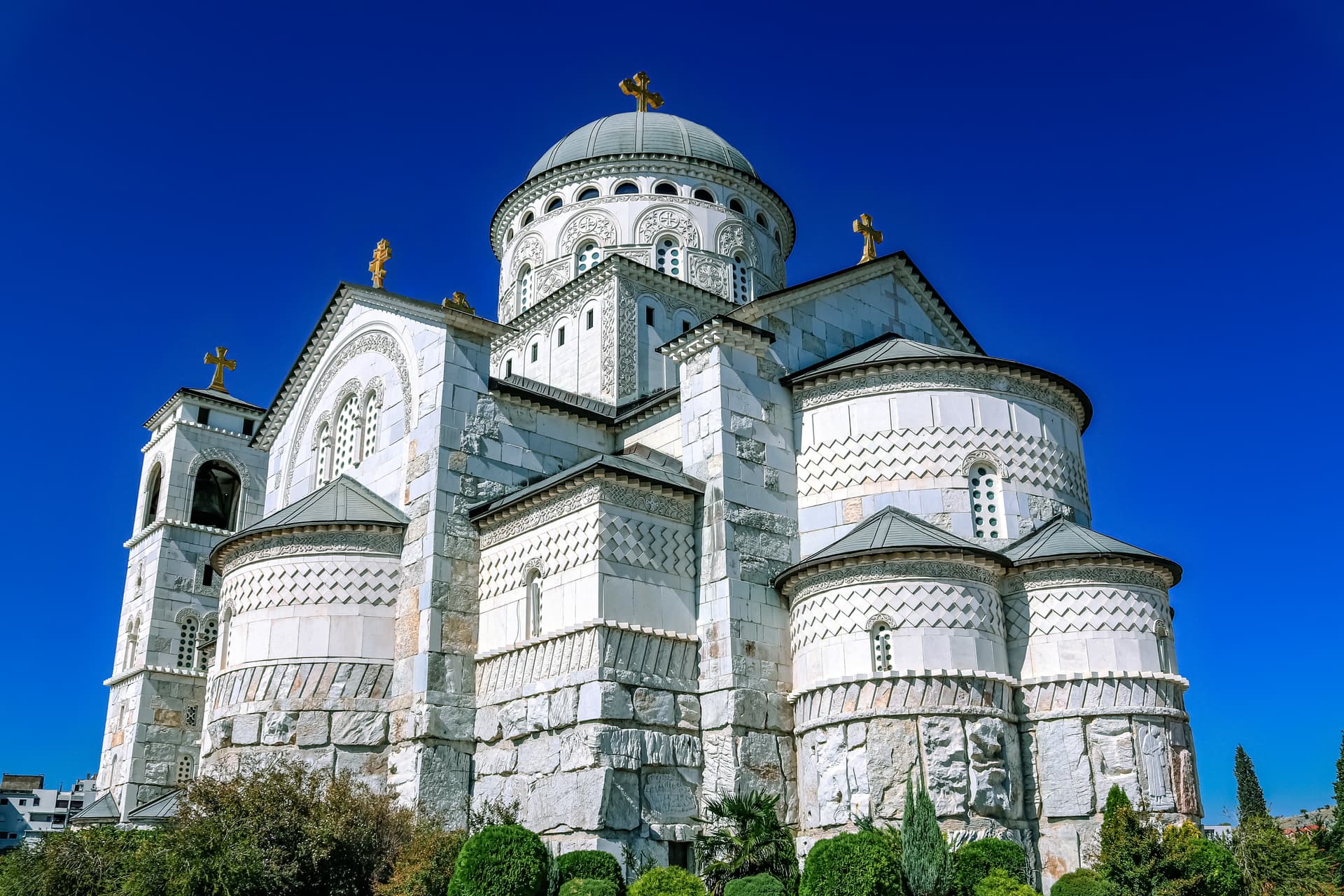 Orthodox Cathedral of Christ's Resurrection in Podgorica, Montenegro, against a bright blue sky.