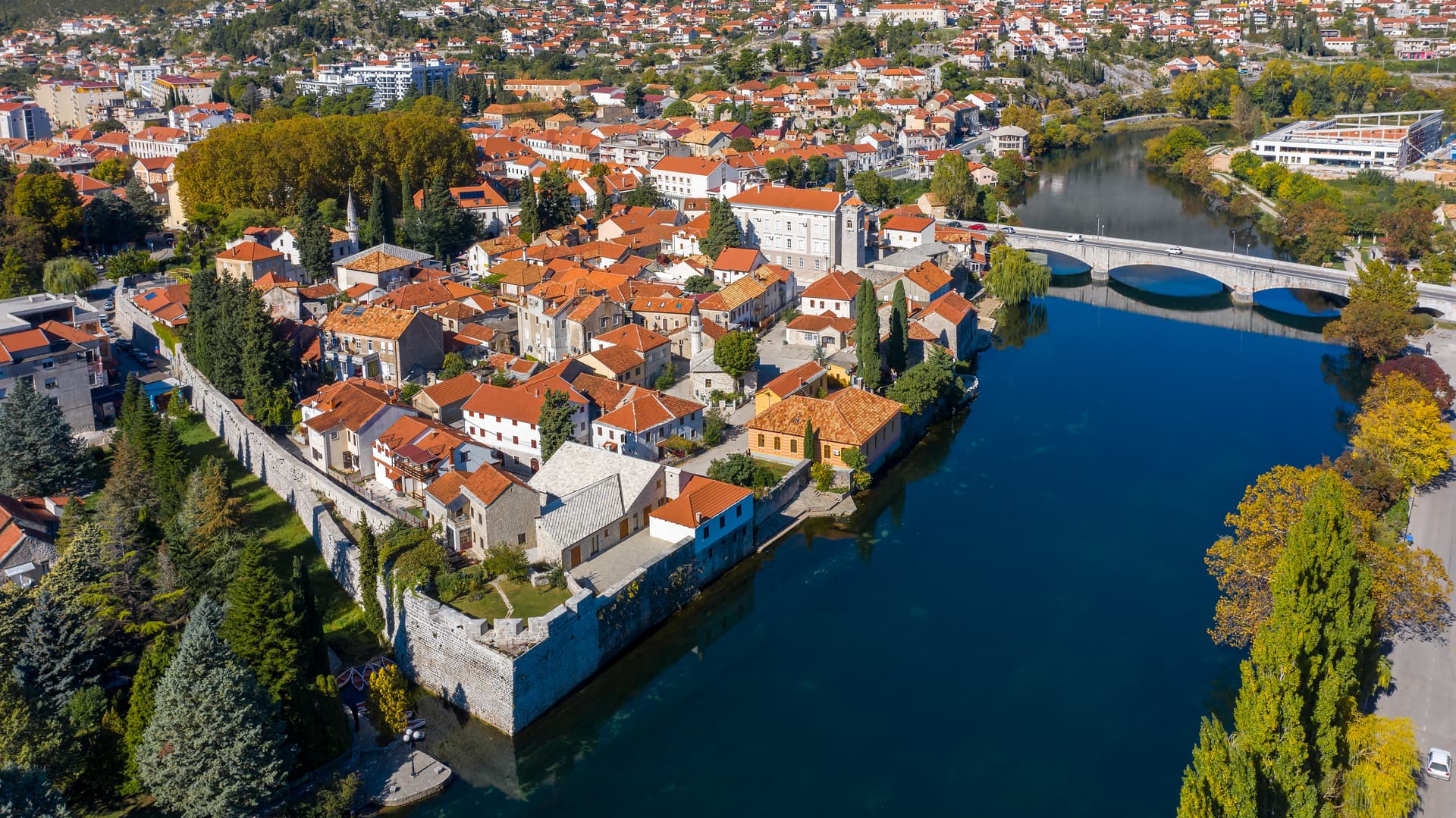 Old town Trebinje with red roofs, stone walls, and the Trebišnjica River in Bosnia and Herzegovina.